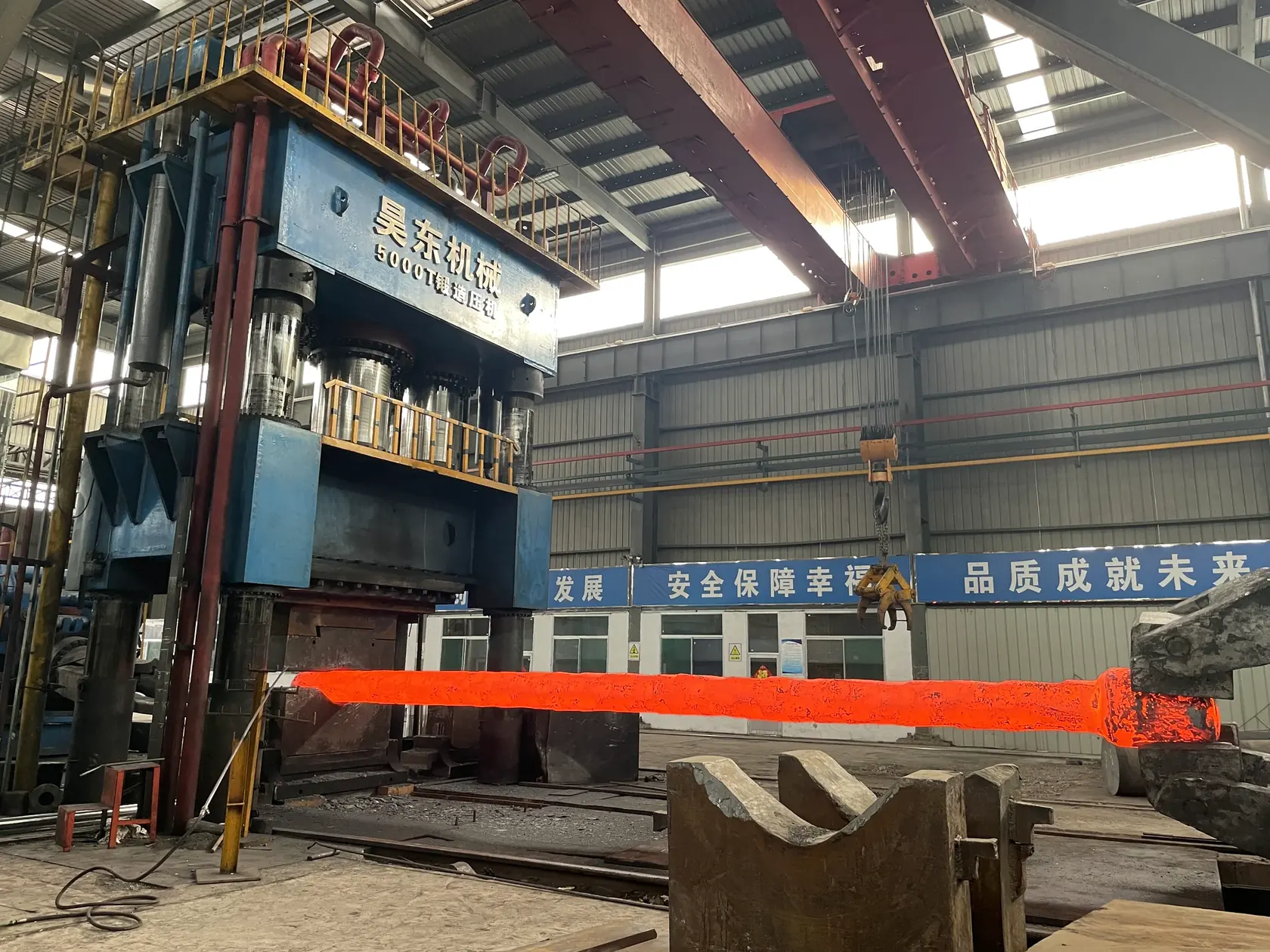 A hot shaft forging beneath the 5,000-tonne press